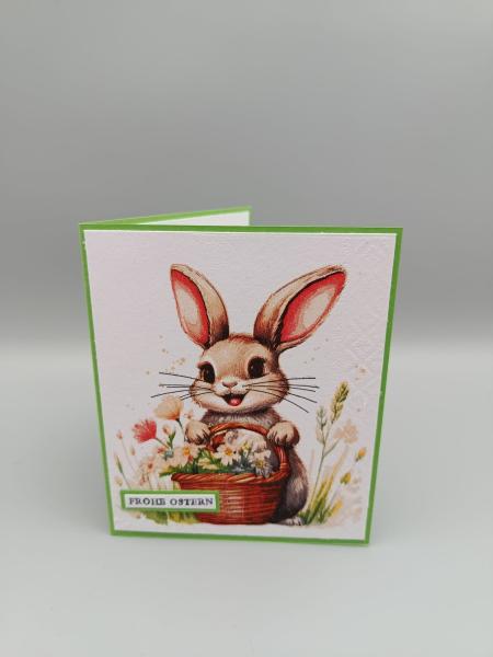 Frohes Ostern Grußkarte — Häschen mit Blumen und grünem Rahmen